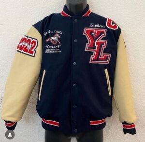 Custom navy blue and cream letterman jacket with embroidered patches and red varsity lettering.