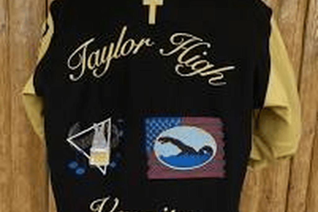 Black and gold letterman jacket with embroidered lettering and custom patches on the back