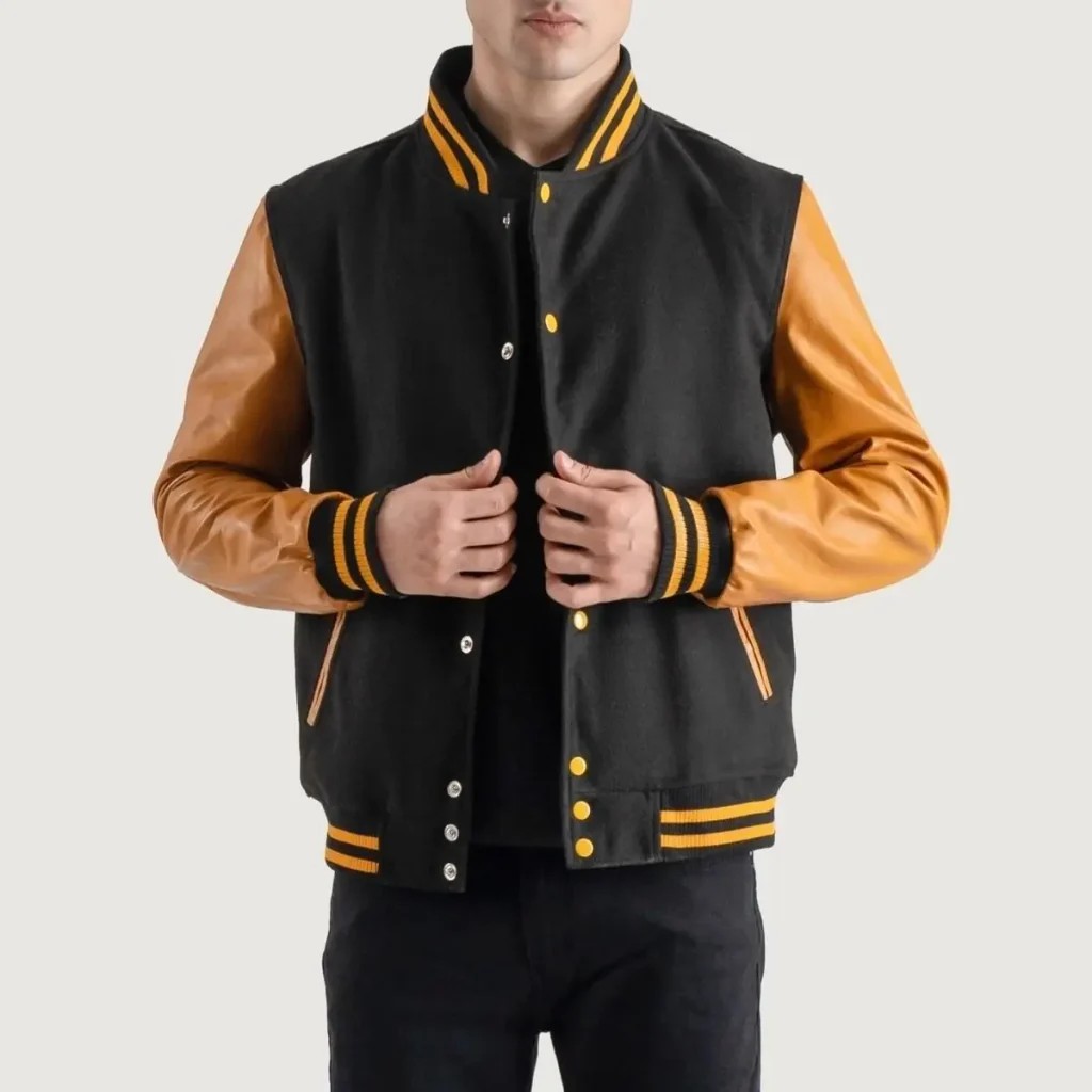 Black varsity jacket with tan leather sleeves and ribbed cuffs.
