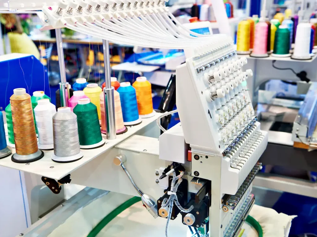 Embroidery thread spools on an industrial machine for custom clothing