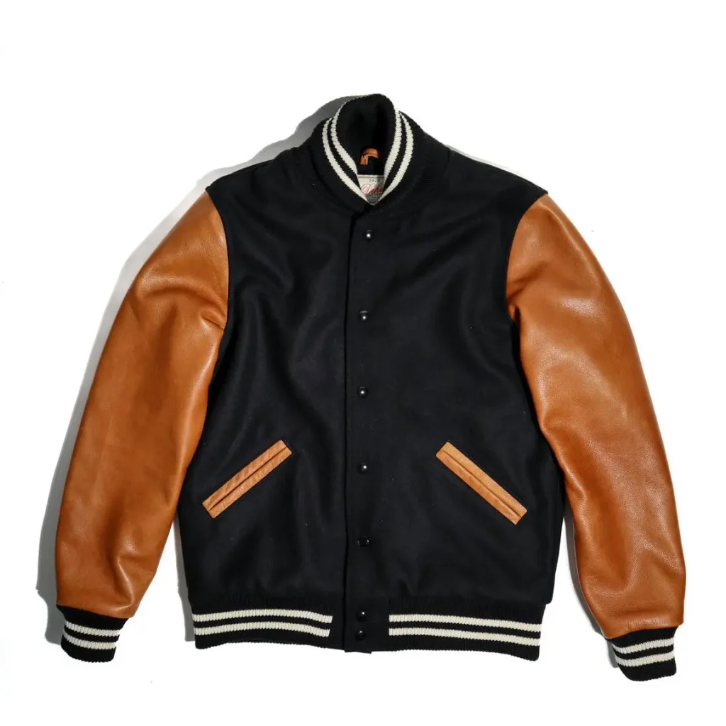 Close-up of a varsity letterman jacket showing contrasting sleeve materials, wool body and ribbed cuffs.