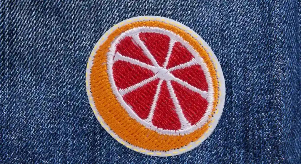 Detailed close-up of a leather patch stitched onto dark fabric